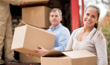 couple loading moving boxes onto truck